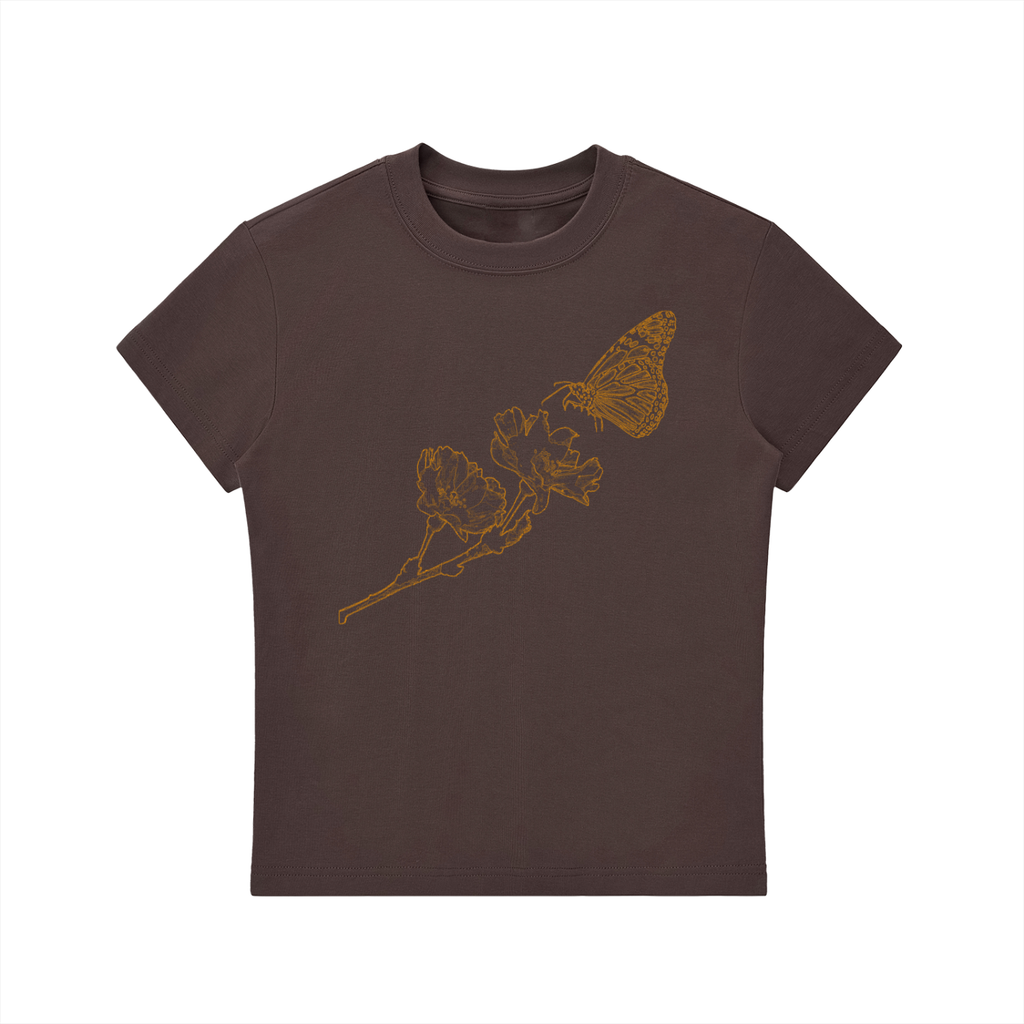 A dark brown short-sleeve crewneck t-shirt featuring a gold line art graphic of a butterfly and leaves on the front, displayed against a solid white background.