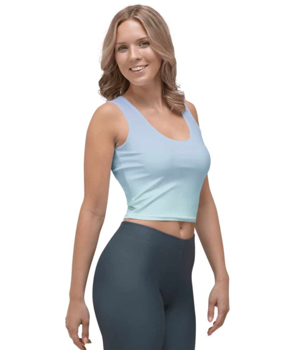 A woman modeling a light blue scoop-neck crop top and dark gray leggings against a plain white background.