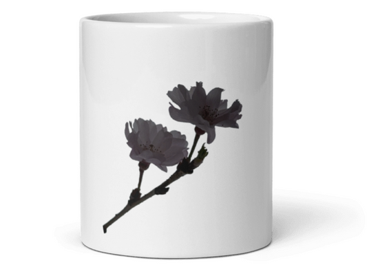 A white ceramic mug featuring a printed graphic of two dark gray blossoms on a branch, set against a plain white background.