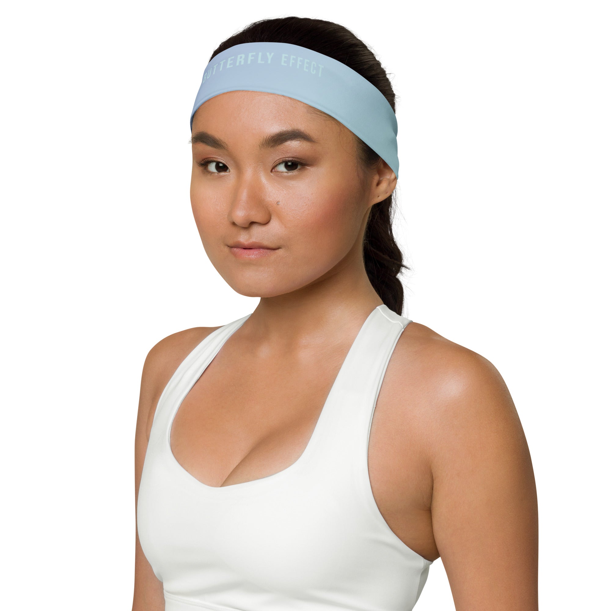 A woman wearing a light blue athletic headband and a white sports tank top, shown from the chest up against a plain white background.