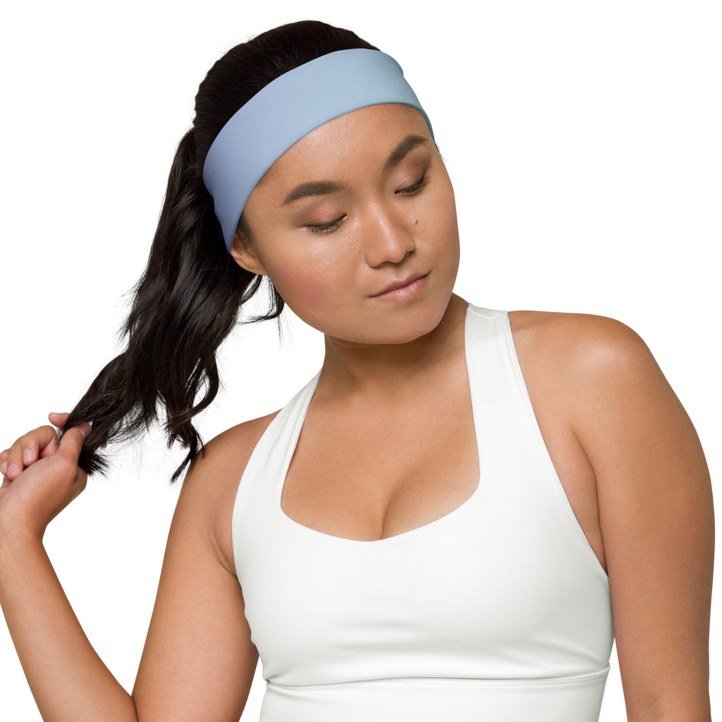 Woman wearing a white tank top and a colorful headband on a white background
