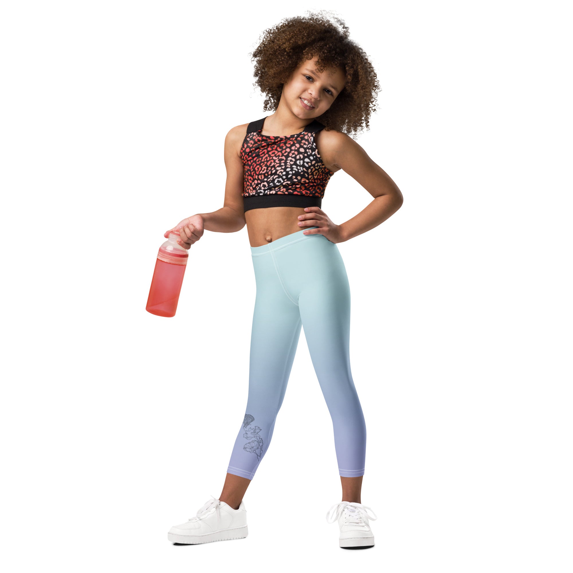 Child wearing a patterned sports top and leggings with a pink water bottle on a white background