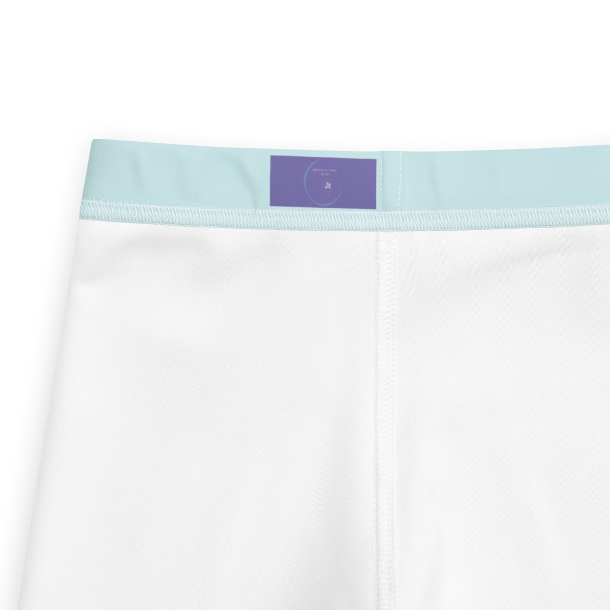 Close-up of white underwear or boxer briefs showing the waistband, with a light blue elastic band and a small purple rectangular label at the center back.