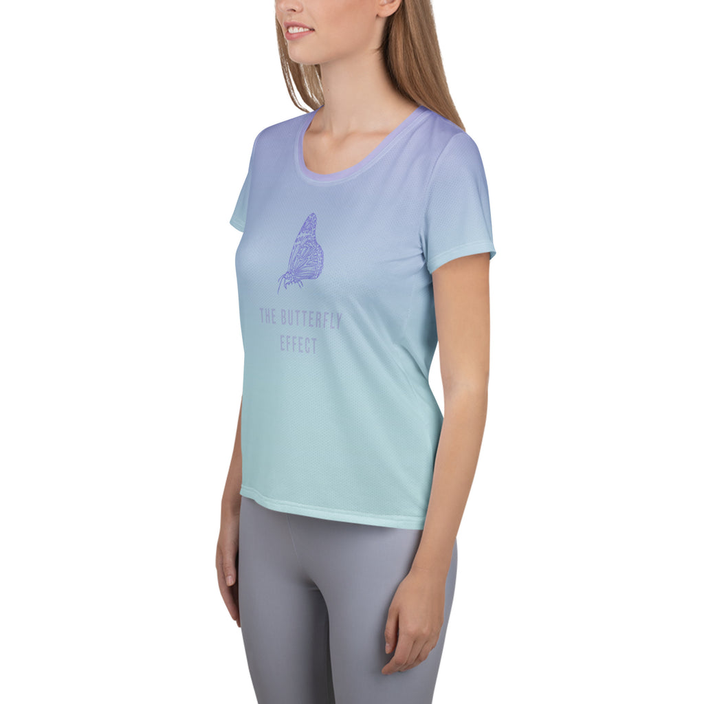 A woman wearing a light blue and mint green gradient short-sleeve t-shirt with a purple butterfly graphic and the text 'THE BUTTERFLY EFFECT' on the front, paired with gray leggings, set against a plain white background.