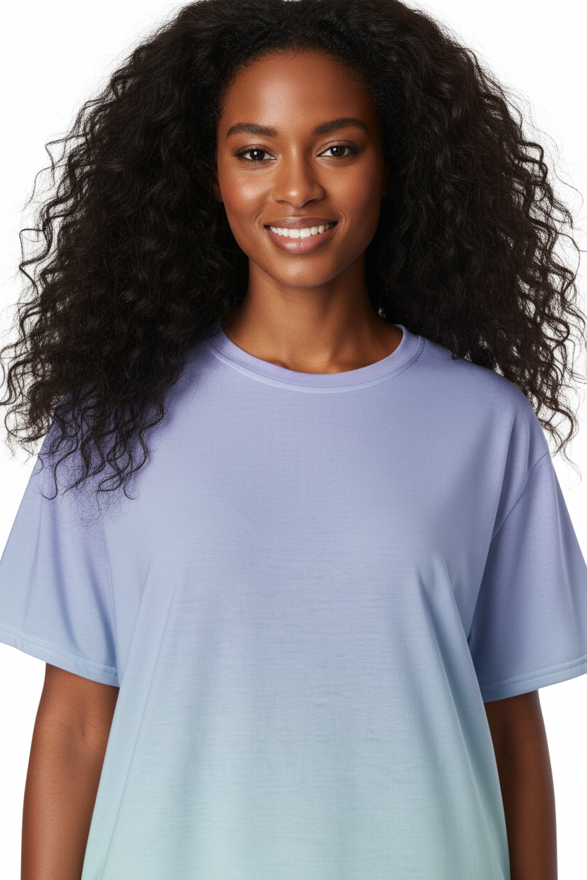 A woman with long, curly black hair wearing a short-sleeve crewneck t-shirt with a vertical color gradient transitioning from light lavender purple at the top to mint green at the bottom, shown against a plain white background.