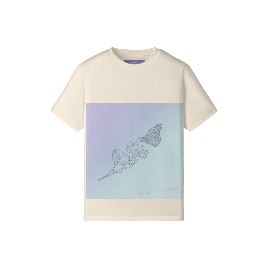 A cream-colored short-sleeve t-shirt with a large square graphic on the front. The graphic features a lavender-to-light-blue gradient background with a delicate line drawing of a butterfly on a flower and the text 'the butterfly effect' in a light purple script.