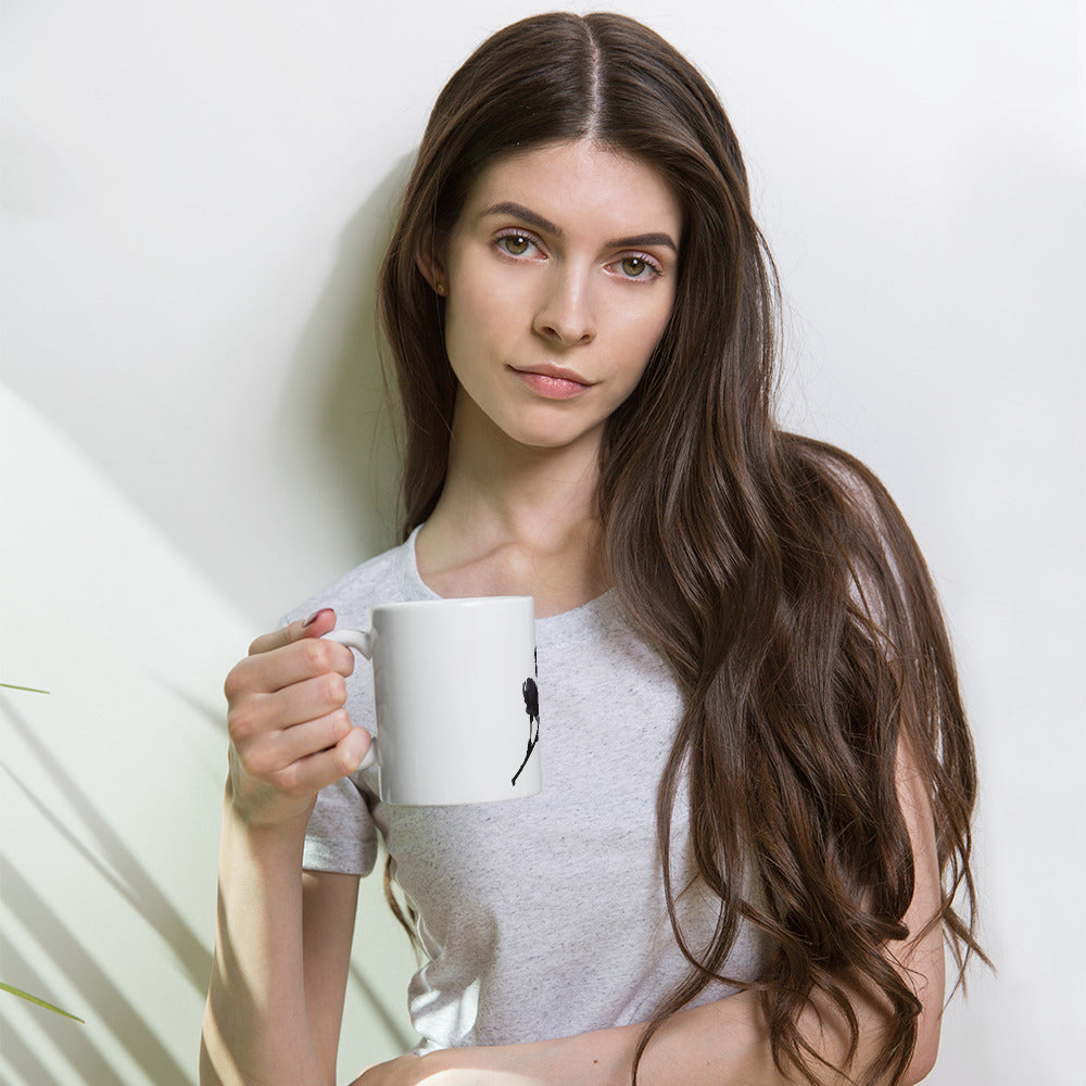 Woman holding a white mug against a plain background